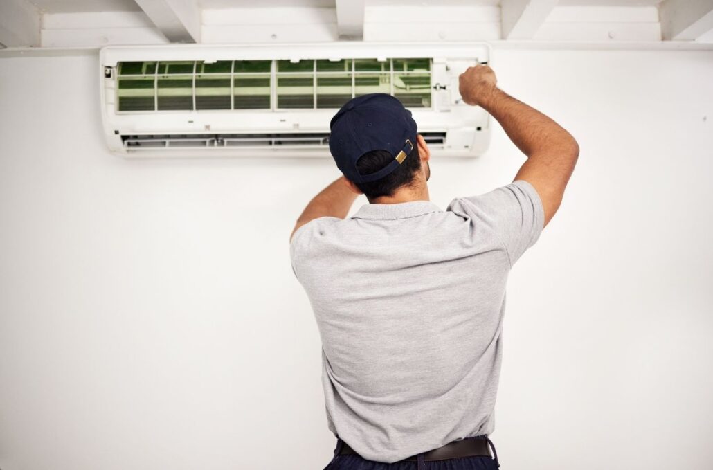 Technician diagnosing failed outdoor AC unit at Okeechobee North home during hot afternoon