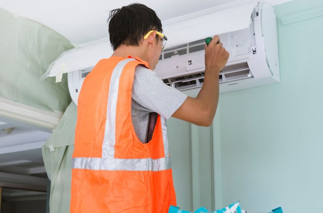 Technician repairing residential air conditioner after midday cooling failure in Okeechobee home