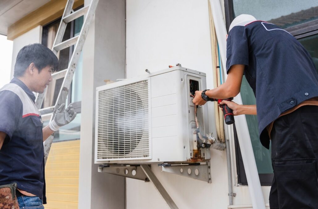 Technician diagnosing warm airflow from residential AC system during hot River Park afternoon